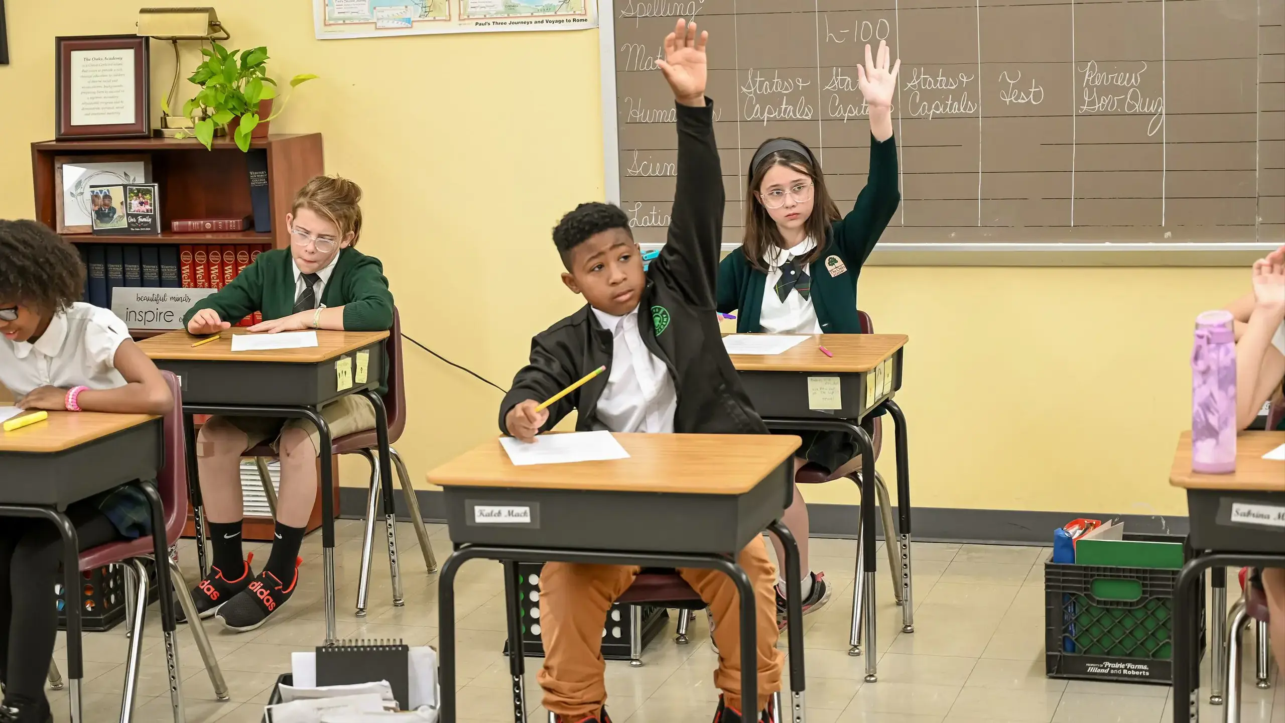 students raising hands in class