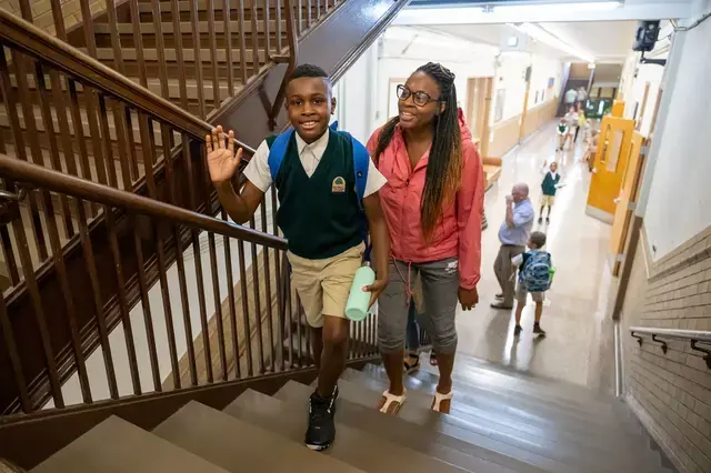 Boy waving on his way to class