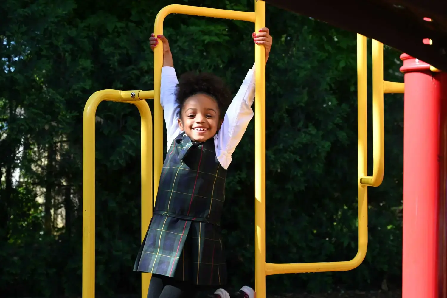 Girl swinging from a climbing frame on the playground at the Brookside Campus.