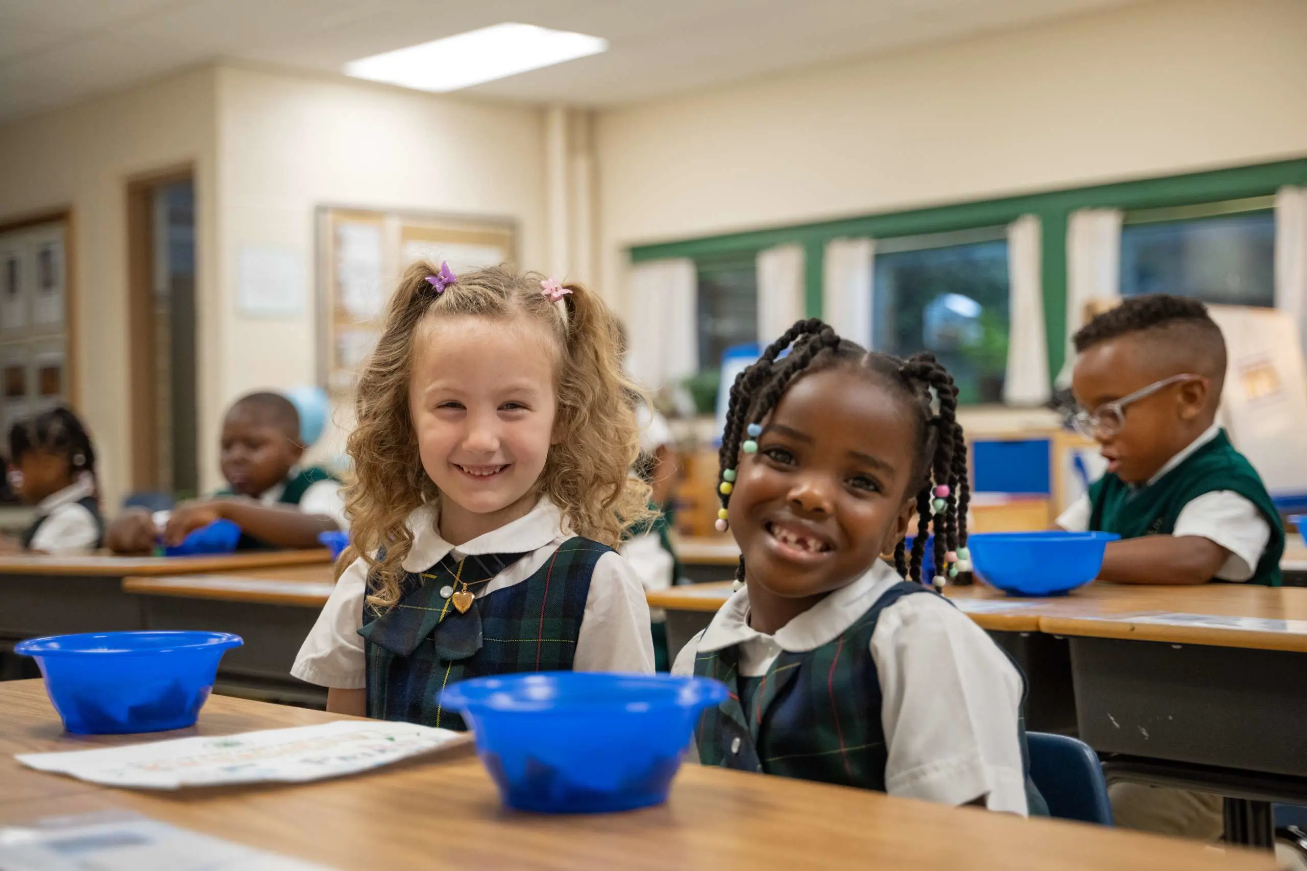 Kindergarten girls smiling during morning activity centers.