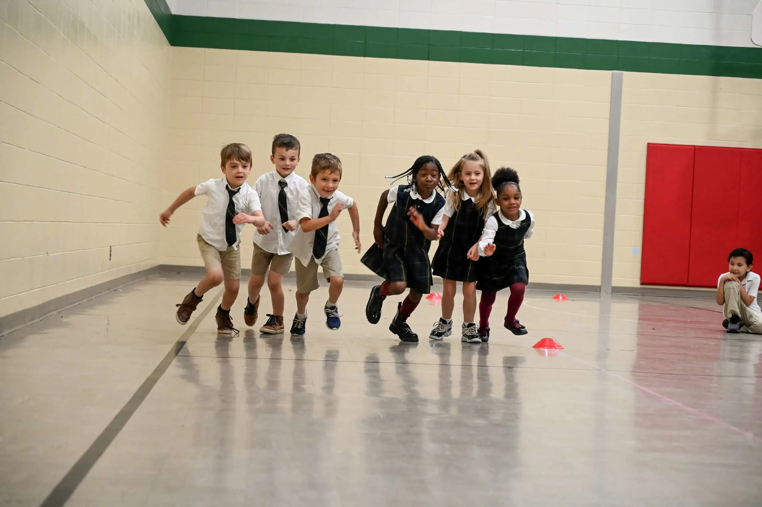 Kindergarten students running in a race together in gym class.