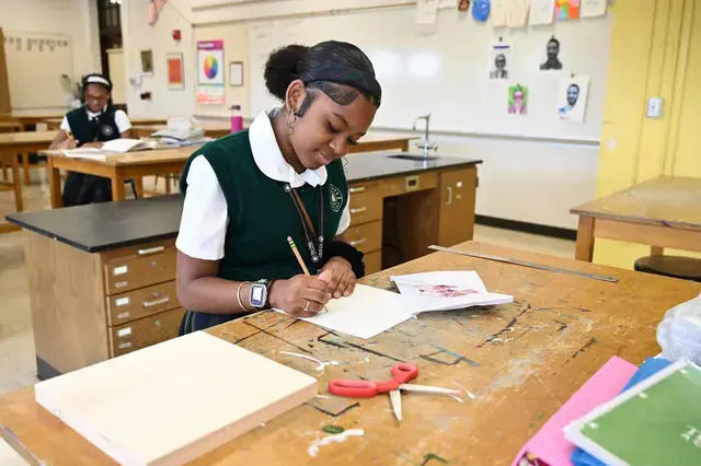 Middle School girl in art studio painting.